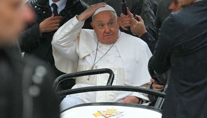 Pope Francis greets bystanders in Leuven during his visit to Belgium on September 27, 2024. — AFP