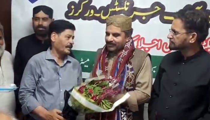 Senior sports journalist Shakil Yamin Kanga giving a bouquet to Sindh Energy Minister Nasir Hussain Shah at the Federal Executive Council (FEC) meeting of Pakistan Federal Union of Journalists (PFUJ) Workers organised by Karachi Union of Journalists (KUJ) Workers seen in this image on September 28, 2024. — Screengrab/Facebook/@SNasirHussainshah