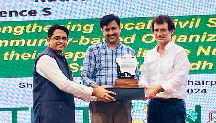 Carlo De Rosa, Development Advisor for Rural Development and Nutrition giving the shield at the Nutrition Care Synergies experience sharing and innovation exhibition held at Shah Abdul Latif University on September 28, 2024. — Facebook/@saluniversity