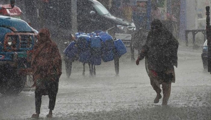 Women walk amid heavy rainfall in the country. — AFP/File