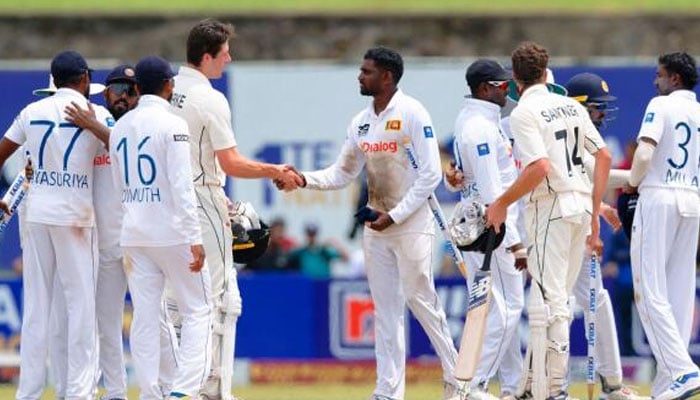 Sri Lankas Nishan Peiris (centre) shakes hands with New Zealands William O’Rourke at the end of the second Test. — AFP