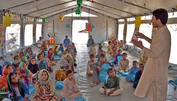 Children studying in a makeshift school in Jafarabads Dera Allah Yar. on September 21, 2022. — AFP