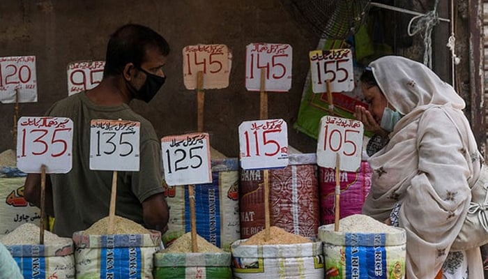 A woman checks the smell of rice at a market. — AFP/File