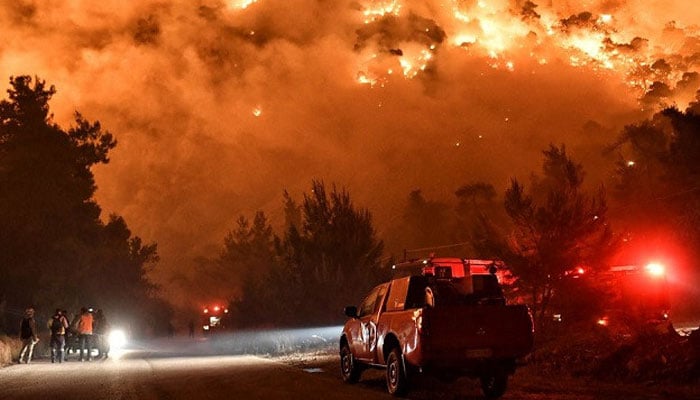 Flames rise as firefighters and volunteers try to extinguish a fire burning in the village of Schinos, near Corinth, Greece, May 19, 2021. — Reuters