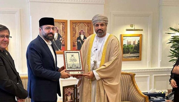 Federal Minister for Overseas Pakistanis and Human Resource Development, Chaudhry Salik Hussain (left) receiving a souvenir from Oman’s Minister of Labour, Dr Mahad bin Said bin Ali (right). — AFP