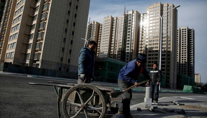 Men work near residential apartment blocks under construction on the outskirts of Beijing, China November 29, 2017. — Reuters