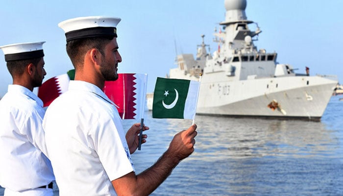 Two Pakistan Navy soldiers waving flag of Pakistan and Qatar.— APP/file