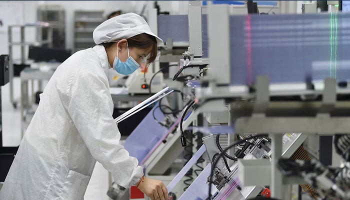 An employee works on the production line of a semiconductor chip company in Suqian, Jiangsu province, China, on February 28, 2023.  — Reuters