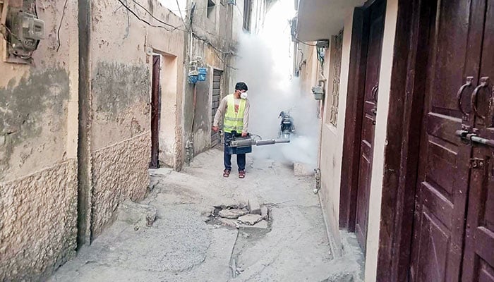 A health worker operates an anti-dengue spray machine in Rehmatabad area of Rawalpindi as part of the ongoing efforts to prevent the spread of dengue fever. — The News/ Khalid Raja