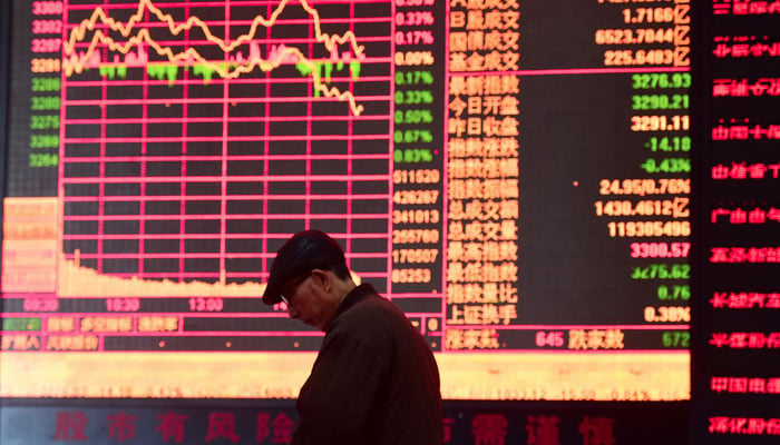 A man is seen against an electronic board showing stock information at a brokerage house in Fuyang, Anhui province, China March 16, 2018. — Reuters