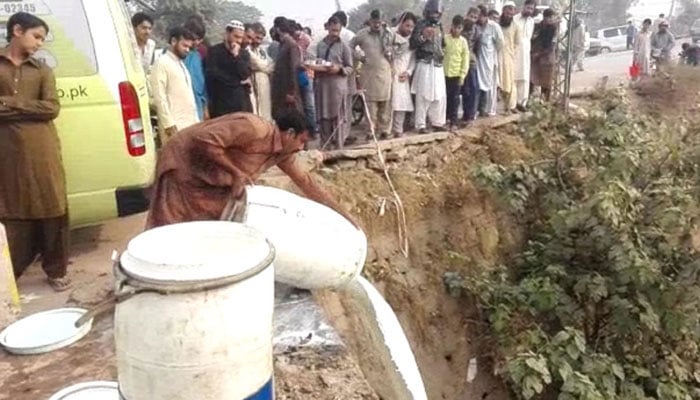 Officials of the Punjab Food Authority (PFA) are removing the substandard milk. — Screenshot via YouTube/Geo News