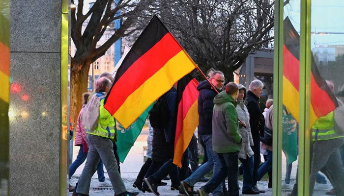 People carry flags of Germany during a demonstration in Chemnitz, Germany, March 18, 2024. — Reuters