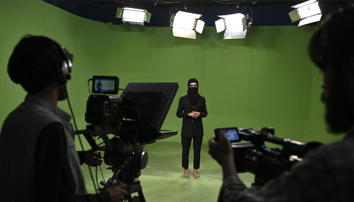 A female media person seen recording a video.— AFP/file