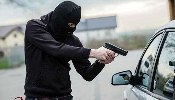 The representational image shows a robber with a gun aimed at a car.  — Unsplash/File