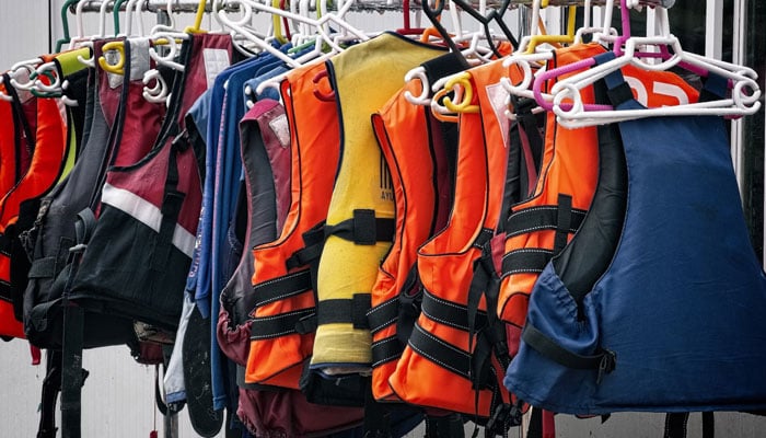 A representational image of hanging life jackets. — Unsplash