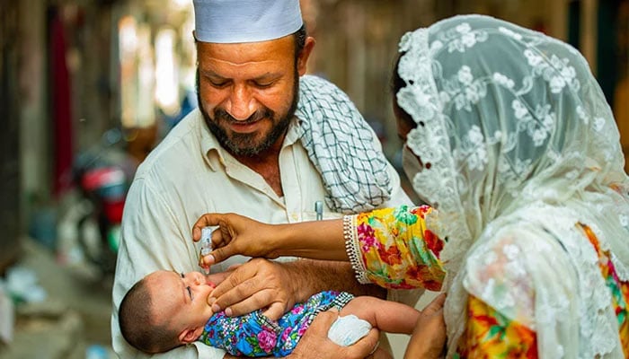 An infant being vaccinated in Maraghzar Colony, Lahore. — WHO/File