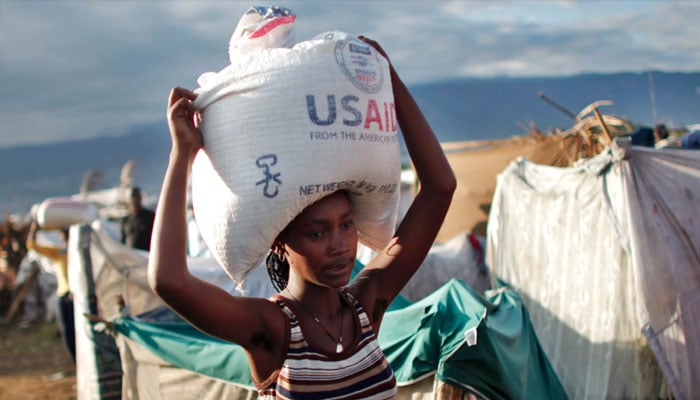 A woman carries a bag of rice distributed by the US Agency for International Development (USAID) in Port-au-Prince, Haiti. — Reuters/file