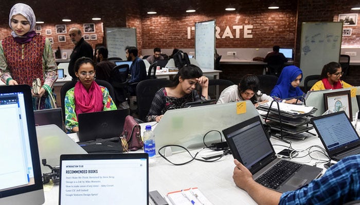 In this photograph taken on May 24, 2019, Pakistani youngsters work at their desks at the National Incubation Centre (NIC), in Lahore, Pakistan.—AFP