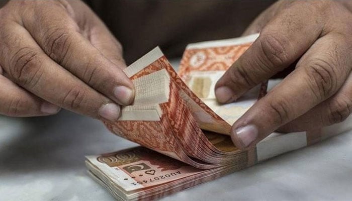 A man counting RS5,000 currency notes. — AFP/File