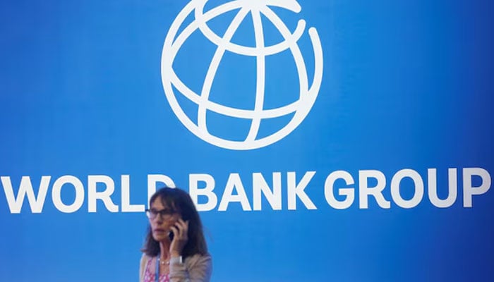 A participant stands near a logo of World Bank at the International Monetary Fund - World Bank Annual Meeting 2018 in Nusa Dua, Bali, Indonesia, on October 12, 2018.   — REUTERS