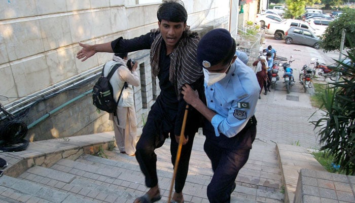 Policeman seen taking away a PTI activist at D Chowk in Islamabad on Oct 4, 2024. — INP