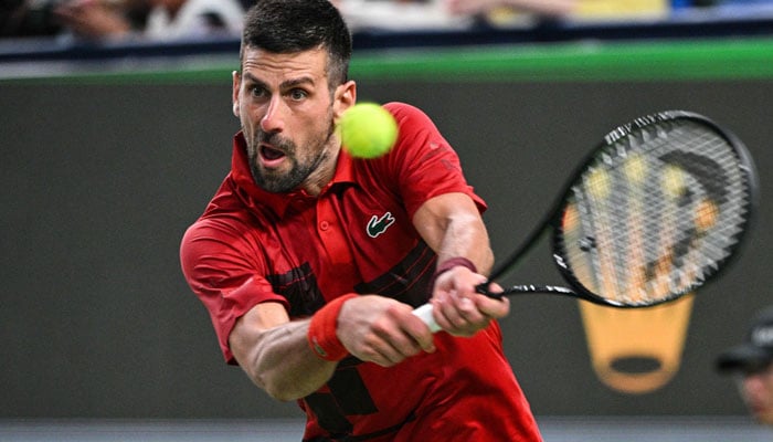 Serbias Novak Djokovic hits a return to USAs Alex Michelsen during their mens singles match at the Shanghai Masters tennis tournament in Shanghai on October 5, 2024. — AFP