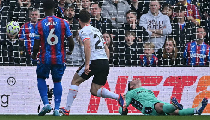 Liverpools Portuguese striker #20 Diogo Jota (C) scores the opening goal past Crystal Palace´s English goalkeeper #01 Dean Henderson (R) during the English Premier League football match between Crystal Palace and Liverpool at Selhurst Park in south London on October 5, 2024. — AFP