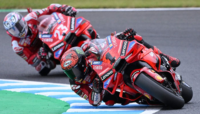 Ducati Lenovo Team rider Francesco Bagnaia of Italy (R) leads his teammate Enea Bastianini of Italy (L) during Tissot Sprint of the MotoGP Japanese Grand Prix at the Mobility Resort Motegi in Motegi, Tochigi prefecture on October 5, 2024. — AFP