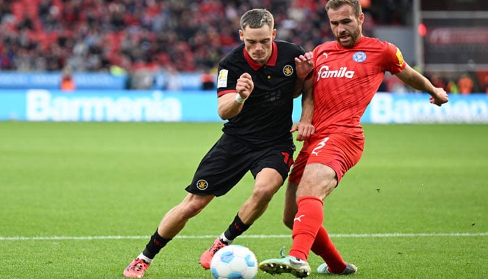 Bayer Leverkusens German midfielder #10 Florian Wirtz (L) and Holstein Kiels German defender #03 Marco Komenda vie for the ball during the German first division Bundesliga football match between Bayer 04 Leverkusen and Holstein Kiel in Leverkusen, western Germany on October 5, 2024.  — AFP