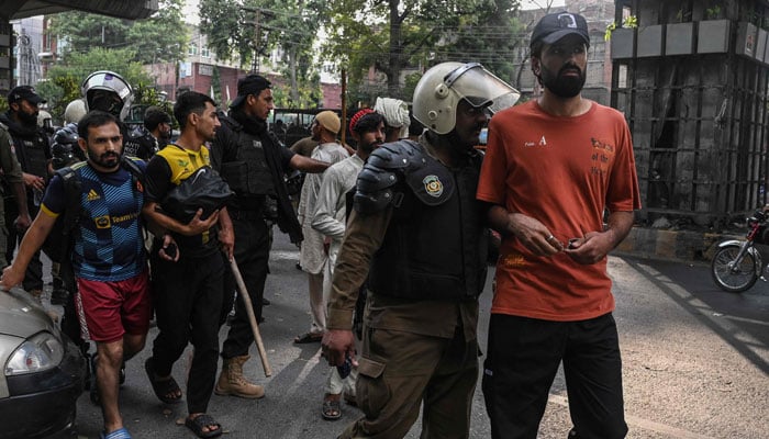 Police personnel detain supporters of former Prime Minister Imran Khans Pakistan Tehreek-e-Insaf (PTI) party during a protest in Lahore on October 5, 2024. — AFP