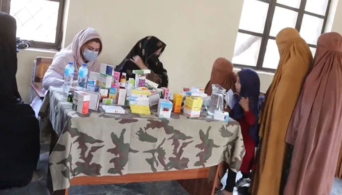 This screengrab taken from a video released on October 30, 2023, shows local female residents seeking medical assistance from the staff accompanied by their children during a free medical camp. — Facebook/Hafiz Abdul Hadi