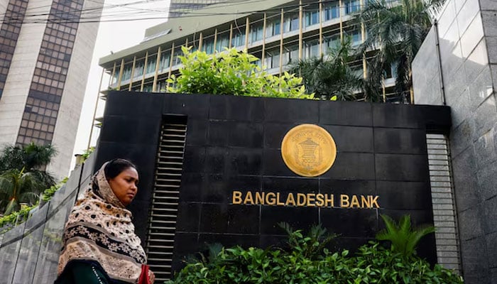 A woman passes by Bangladeshs central bank in Dhaka, Bangladesh, on July 19, 2023. — Reuters