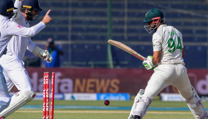 Pakistans Shan Masood (R) is bowled out by Englands Jack Leach (not pictured) during the third day of the third cricket Test match between Pakistan and England at the National Stadium in Karachi on December 19, 2022. — AFP