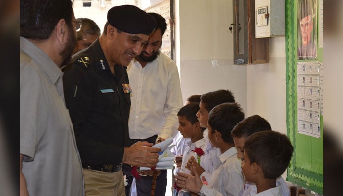 Sindh police chief IG Ghulam Nabi Memon speaks with children during his visit to the Green Crescent Trust’s (GCT) charitable school in Mehran Town on October 2, 2024. — Facebook/Green Crescent Trust