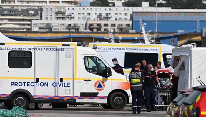 Firefighters provide assistance to an injured migrant after a vessel carrying dozens trying to cross the Channel to England sank off the northern French coast. AFP/file