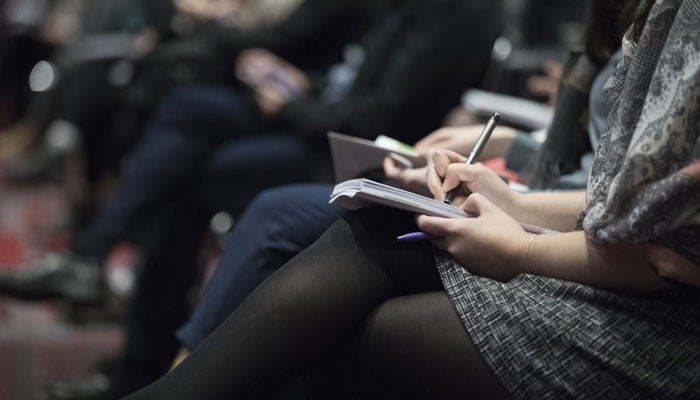 This representational image shows a female journalist writing on paper. — Unsplash/File