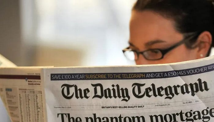 A woman reading a newspaper.— AFP/file