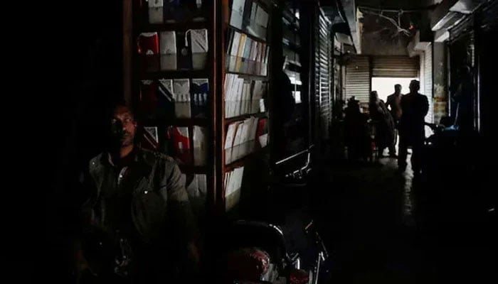 A man sits outside his shop during a power breakdown in Mansehra city Khyber Pakhtunkhwa Pakistan. — Reuters/File