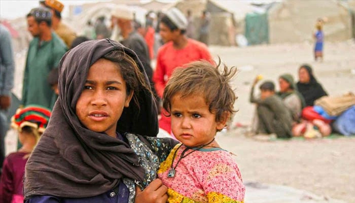 A representational image showing a young girl carrying an infant. — Reuters/File