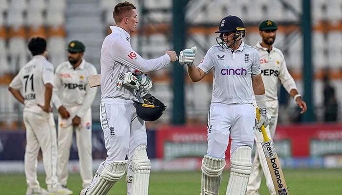 Englands Zak Crawley (L) and Joe Root (C) walk back to the pavilion at the end of the second day of the first Test cricket match between Pakistan and England at the Multan Cricket Stadium in Multan on October 8, 2024. — AFP