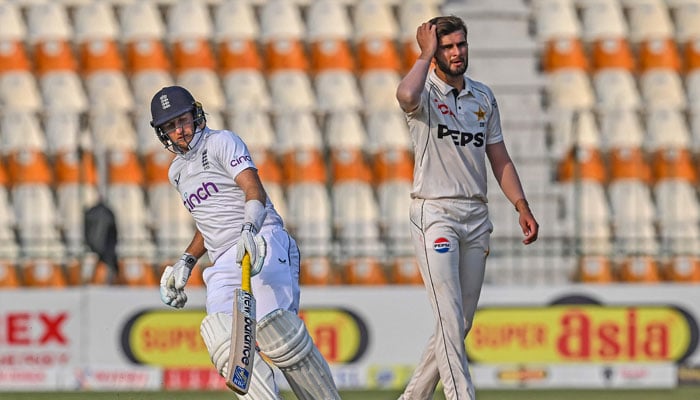 Englands Joe Root (left) runs between the wickets as Pakistans Shaheen Shah Afridi gestures during the second day of the first Test cricket match between Pakistan and England at the Multan Cricket Stadium in Multan on October 8, 2024. — AFP