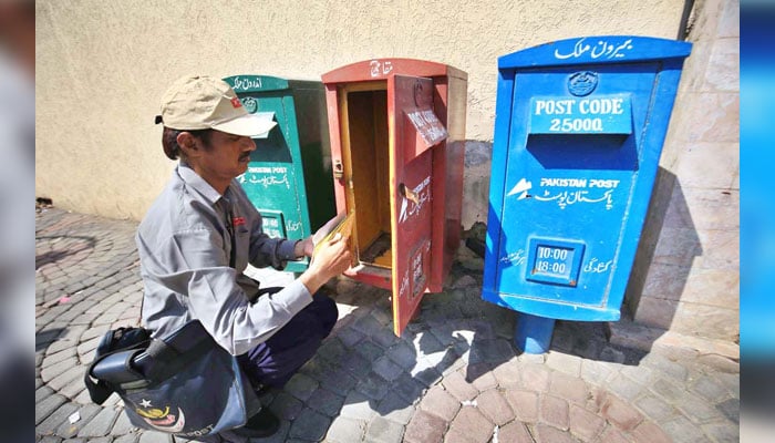 A postman is collecting letters from a post box at GPO Cantt for further delivery as the world celebrates World Post Day on 9th October image released on October 8, 2024. —  APP