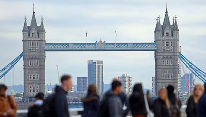 People walk over London Bridge looking at a view of Tower Bridge in the City of London financial district in London, Britain, October 25, 2023. — Reuters