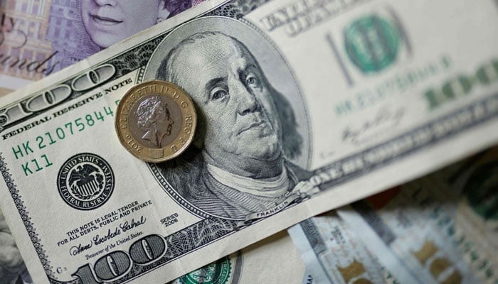 In this file photo taken on April 22, 2022 US dollar coins and banknotes are seen displayed on a table, in London. — AFP