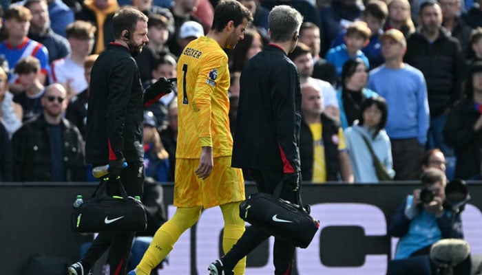 Liverpool goalkeeper Alisson Becker leaves the pitch after picking up an injury against Crystal Palace. — AFP/file