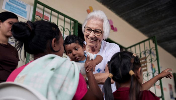 Brazilian nun Sister Rosita Milesi, who is the Global Laureate of the 2024 UNHCR Nansen Refugee Award, holds baby Daniel Jose Milaro, who has just arrived from Venezuela with his mother Jenifer Milaro and siblings, at the Casa de Acolhida Sao Jose, a temporary shelter for refugees and migrants in Pacaraima, Brazil, August 24, 2024. — UNHCR