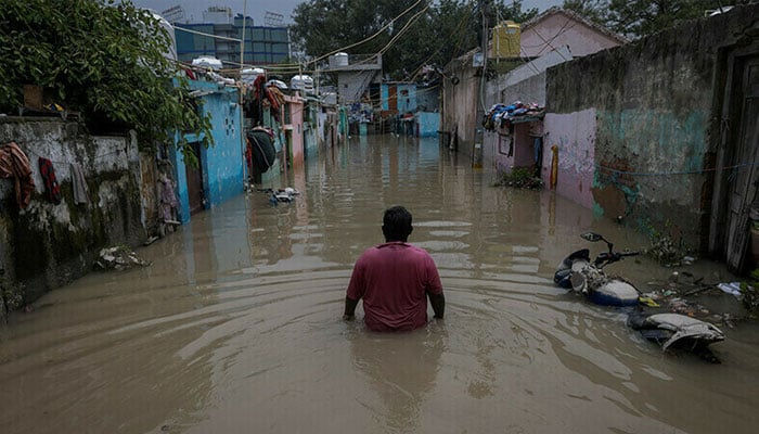 A man walks through a flooded alley at a residential colony, after water rose from the river Yamuna due to heavy monsoon rain, in New Delhi, India, in this file photo from July 2023. — Reuters