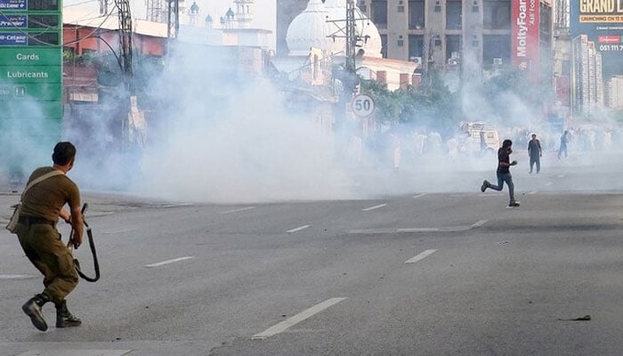 A policeman fires teargas shell towards supporters of Pakistans jailed former prime minister Imran Khans Pakistan Tehreek-e-Insaf (PTI) party, during a protest demanding his release in Rawalpindi on September 28, 2024.  — AFP/File