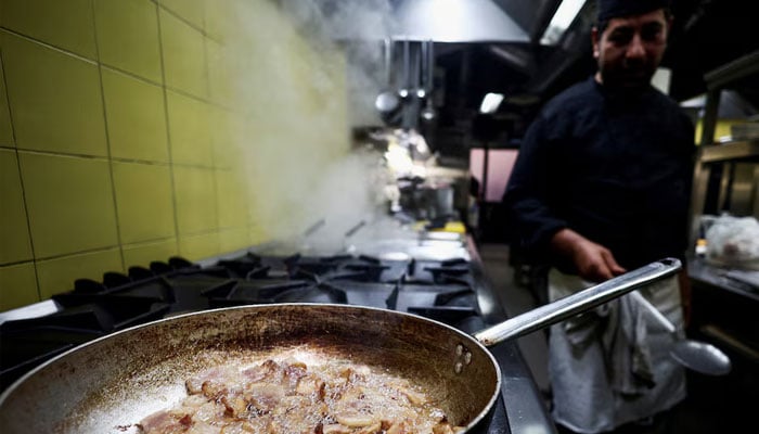 A cook prepares pasta Carbonara at La Carbonara restaurant in Campo de Fiori in Rome, Italy, December 14, 2023. — Reuters