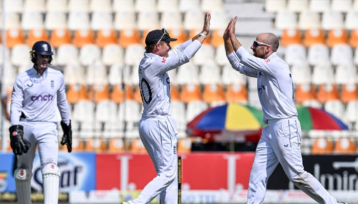 England´s captain Ollie Pope (C) celebrates with teammate Jack Leach (R) after winning the first Test cricket match between Pakistan and England at the Multan Cricket Stadium in Multan on October 11, 2024. — AFP